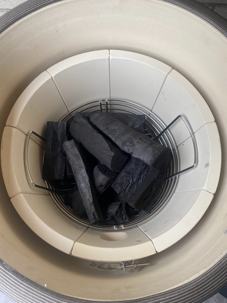 extra grote stukken eucalyptus-houtskool in de vuurkorf van een kamado