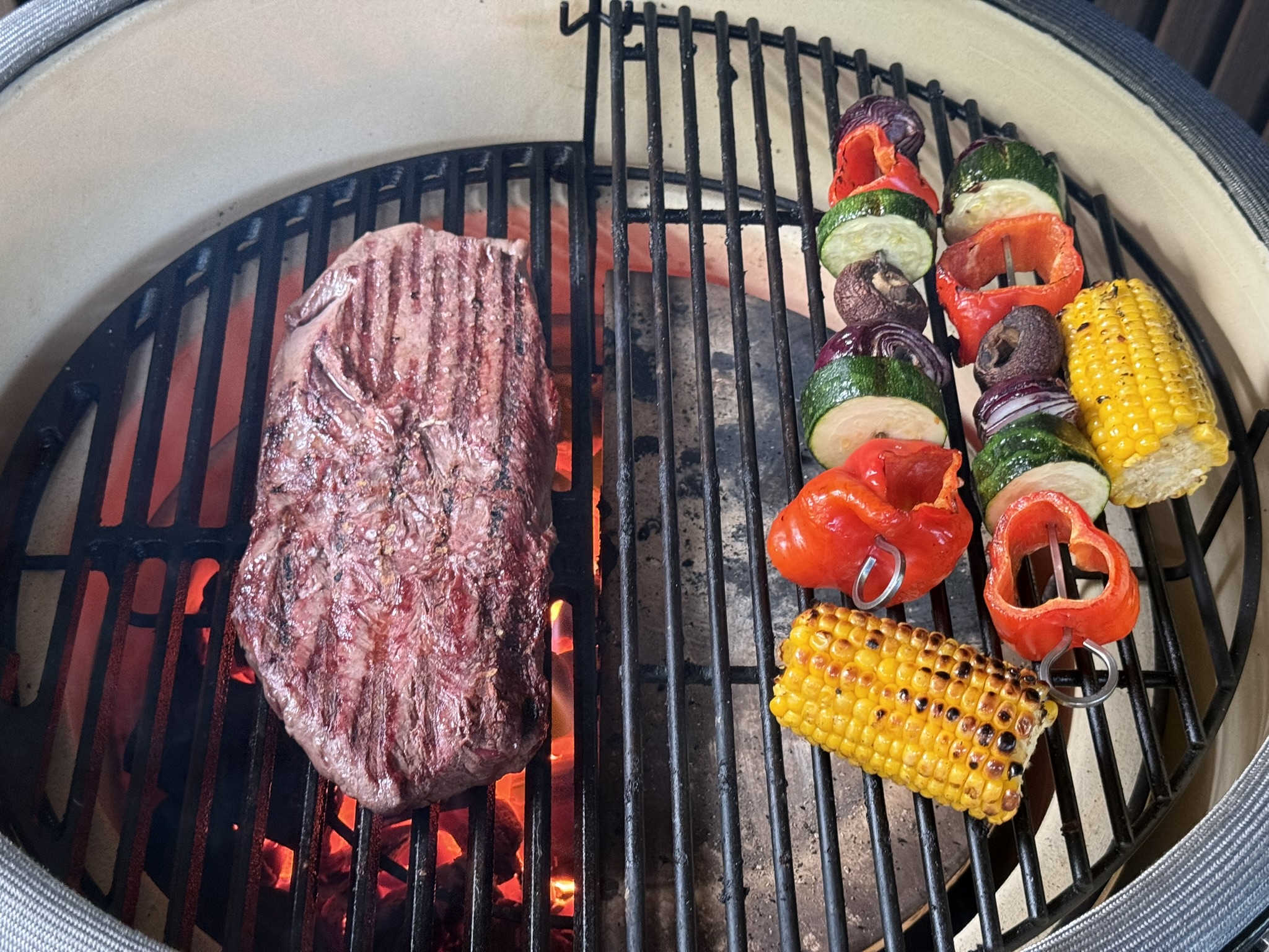 Flat iron steak met diamantruit van grillstrepen op het gietijzeren rooster van de kamado