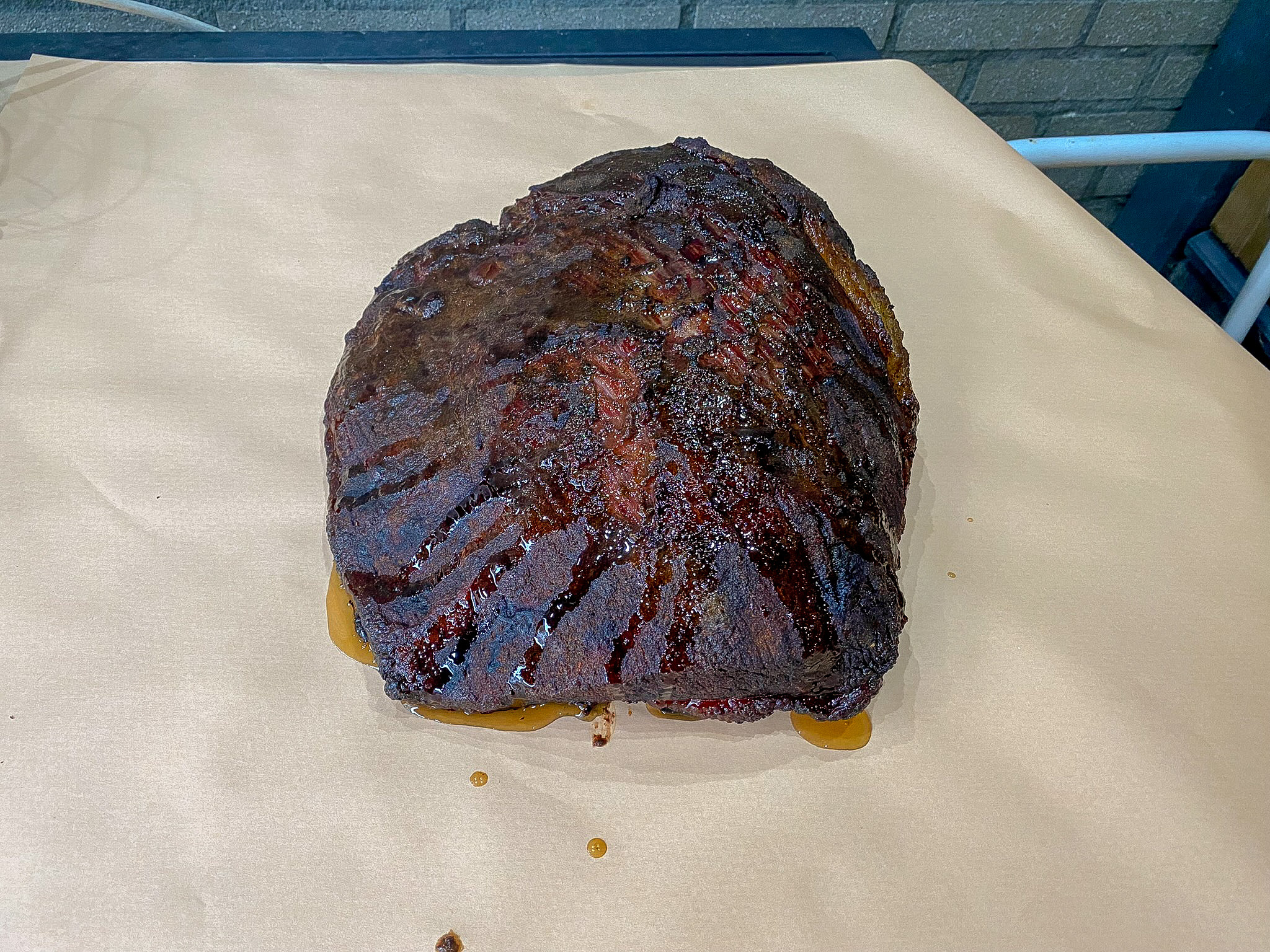 Brisket met een donkere bark op een vel butcher paper, klaar om in te pakken